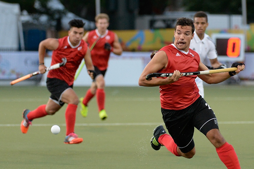 Matthew Sarmento of team Canada chases the ball during a quarter-final men’s field hockey match at the Pan Am Games in Toronto on Tuesday. Canada won the match 3-1 against Trinidad and Tobago.