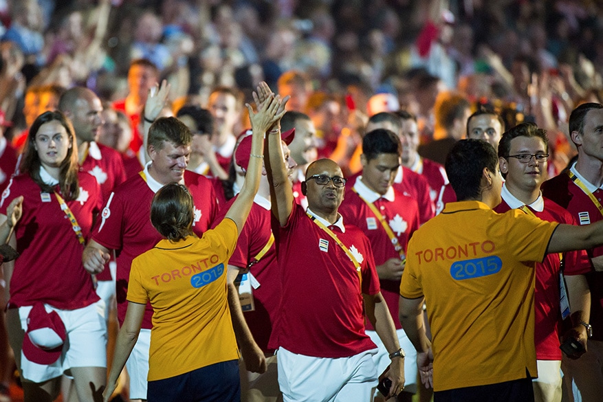 A Canadian athlete high-fives a volunteer during the closing ceremonies of the Toronto 2015 Pan Am Games. 