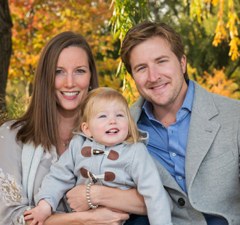 Beautiful young couple holding their toddler during a fall family photo shoot