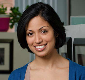 Headshot for young professional woman sitting and smiling in a corporate office