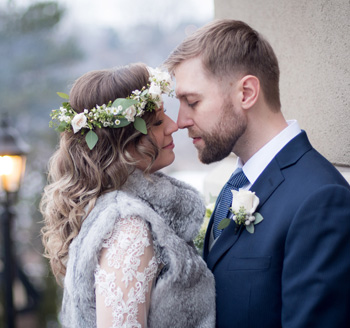 European newlyweds pose for wedding photos wearing floral accents