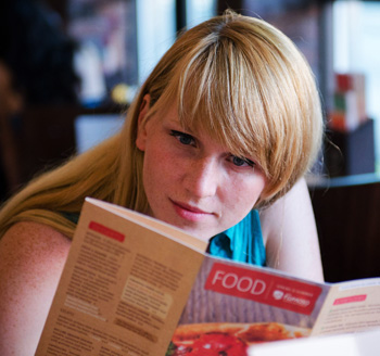 Commercial photo of a restaurant patron browsing the food menu for something to eat